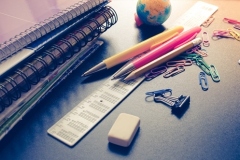 School supplies on blackboard background. Back to school concept with stationery. Notebook stack pens and pencil. Schoolchild and student studies accessories. Back to school concept. Toned image.